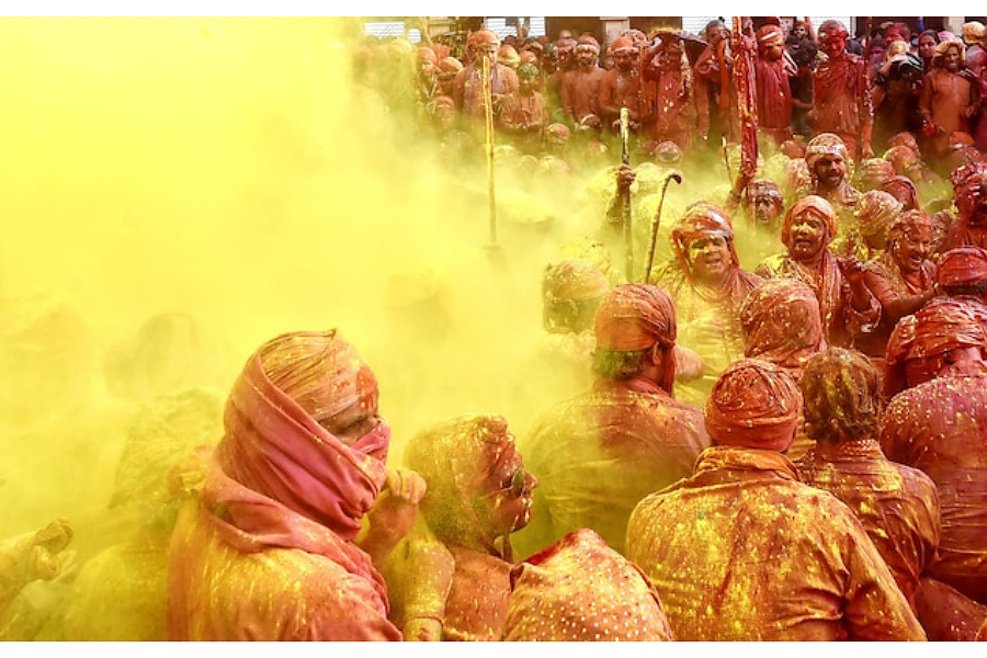 Участниците в индийския фестивал Холи се замерват с разноцветен прах.
